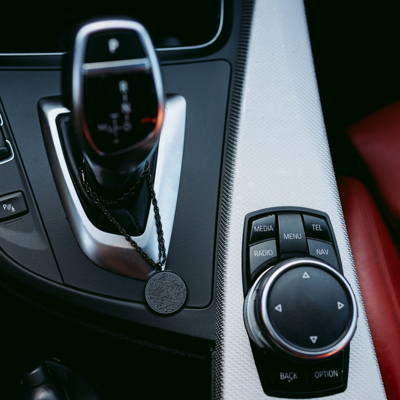 Close up of the black Ayatul Kursi Car Hanger on a car gear stick.