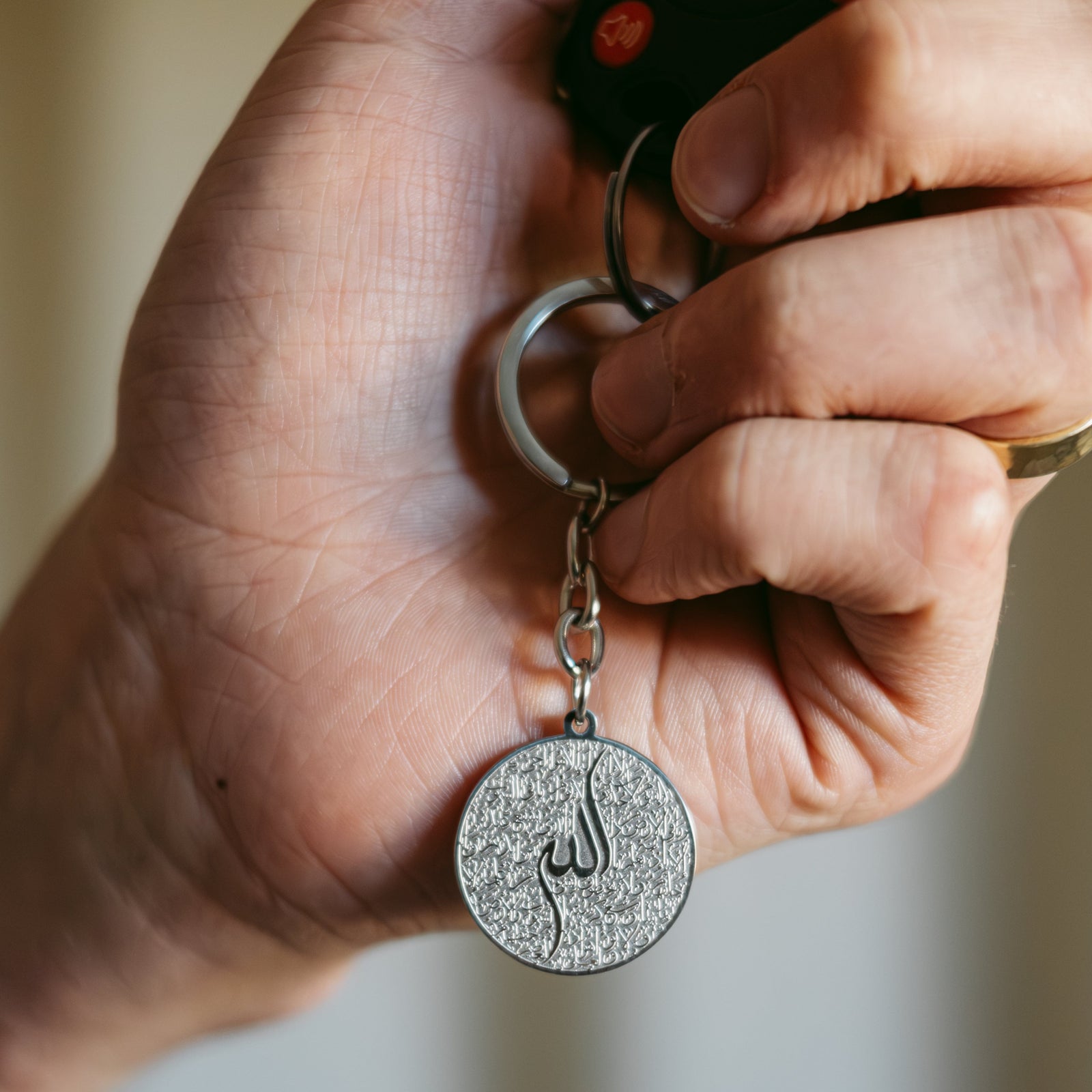 Model holds the silver Ayatul Kursi Keychain V2.