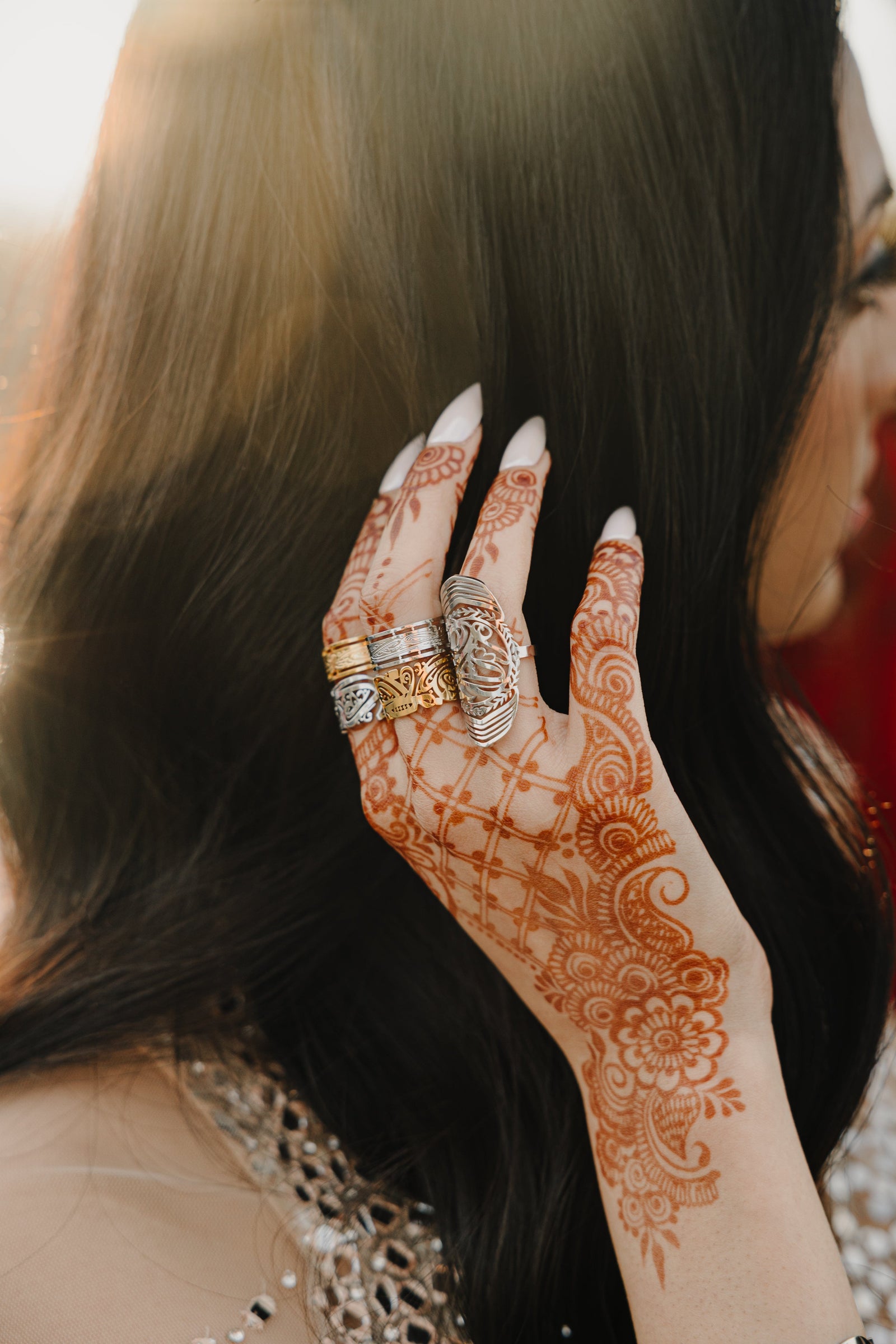 Model wearing gold and silver Ease rings stacked with other rings.