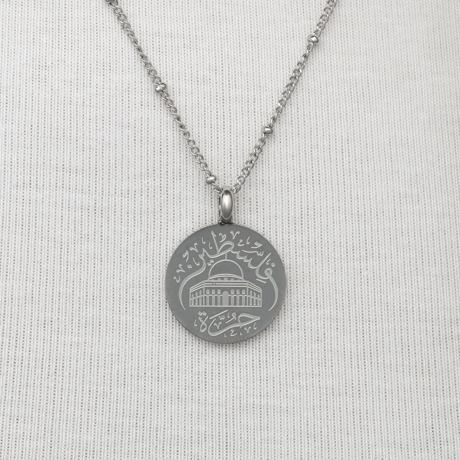 Silver Al-Aqsa ‘Free Palestine’ Necklace on a light gray background