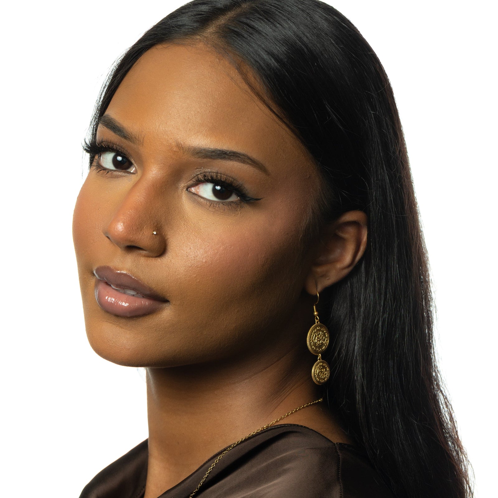 Photo of the model looking at the camera. The model is wearing the gold earring on their left ear.