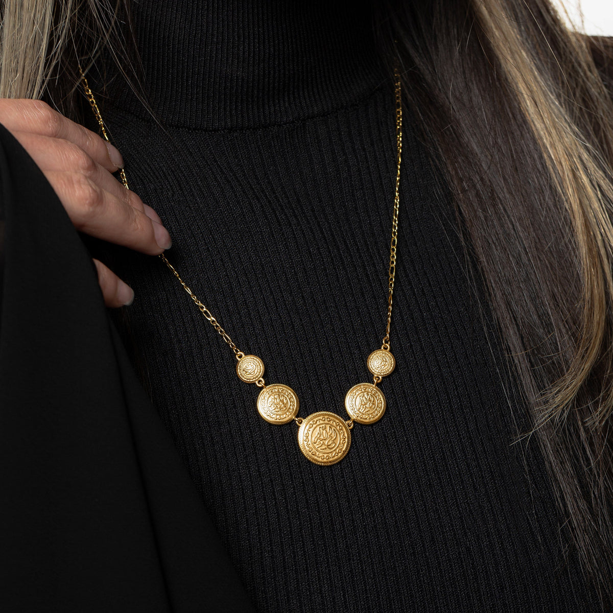 Model wearing the gold Alhamdulillah Coin Necklace, touching its thin chain.