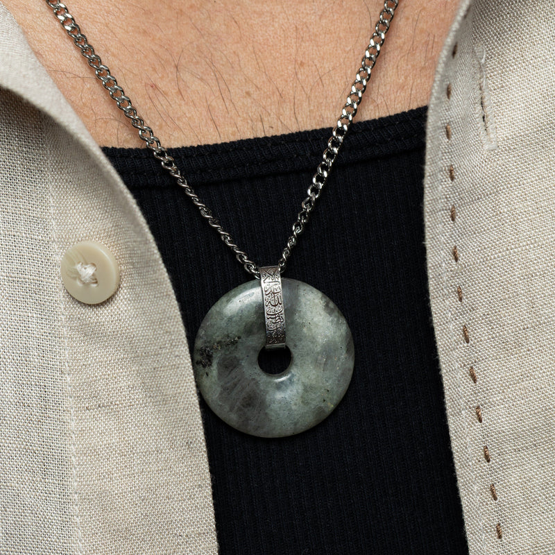 Zoomed-in detail of the labradorite stone pendant pimage_ highlighting its natural gray-green marbling and silver bail engraved in Arabic calligraphy.