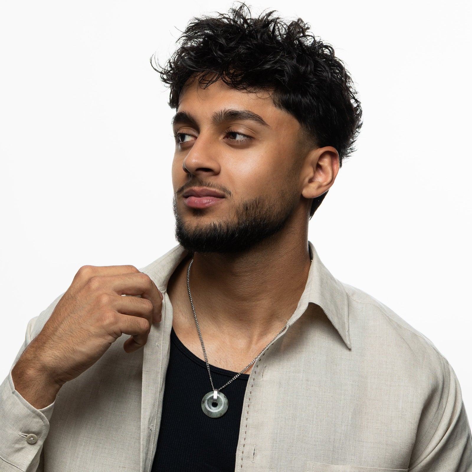 Man wearing the labradorite stone necklace on a silver chain, styled with a black shirt and beige button-down, looking slightly to the side.