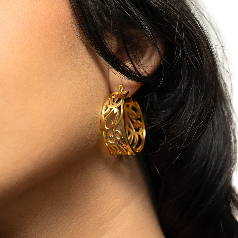 gold “Allah does not burden a soul beyond what it can bear” Earrings on a woman's ear