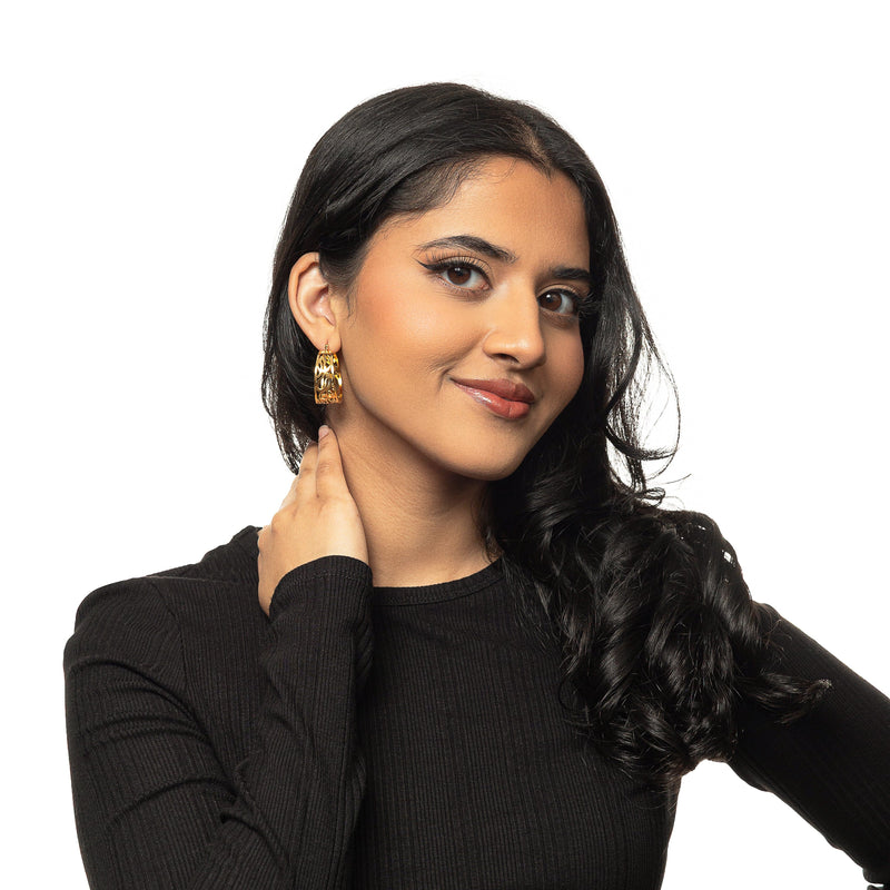 a woman wearing the gold “Allah does not burden a soul beyond what it can bear” Earrings