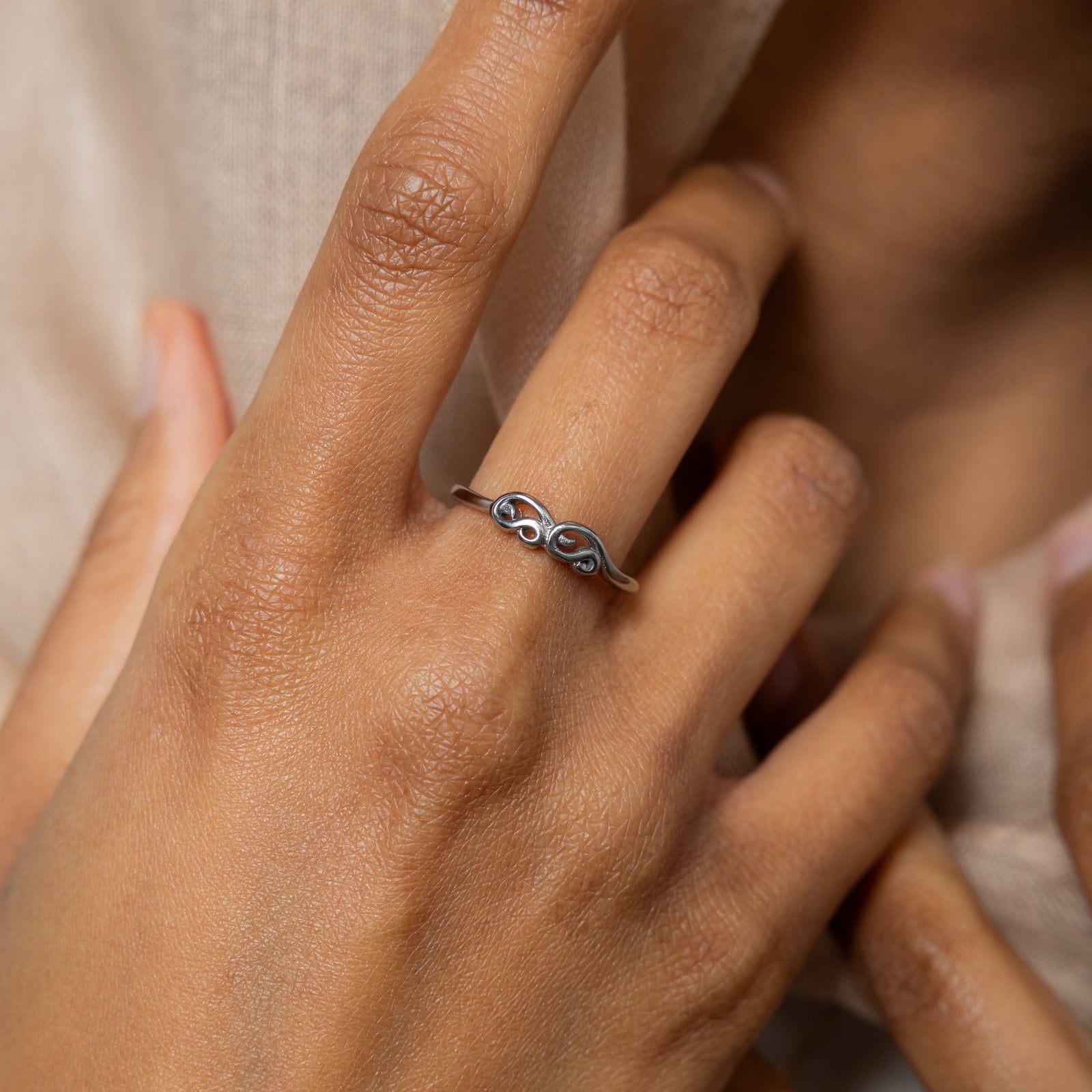 A model showcasing the silver Arabic Mama Ring on her finger. 