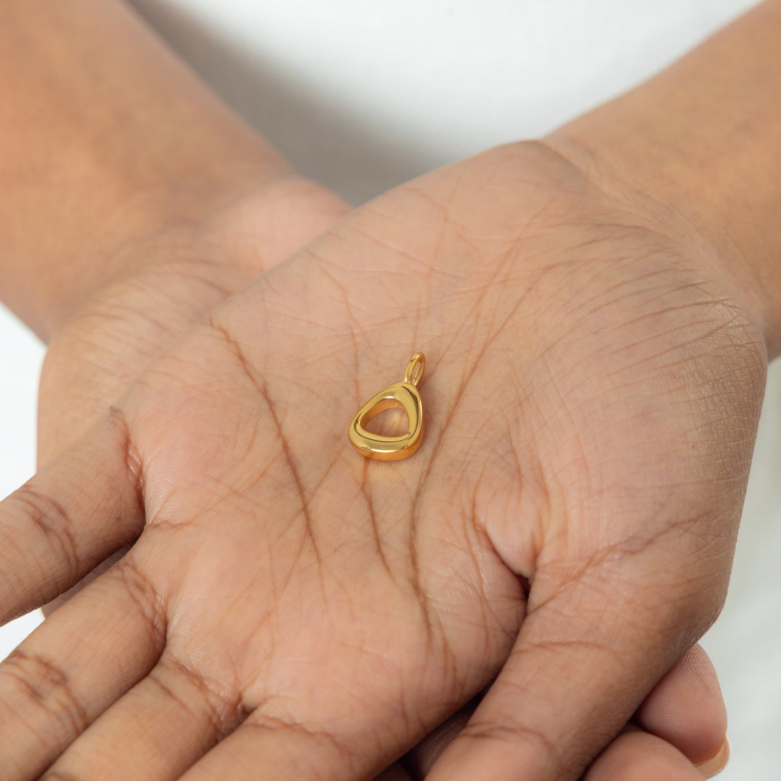 Close-up of the gold-plated Arabic number charm "5" ( featuring the same pearl backdrop and smooth finish.