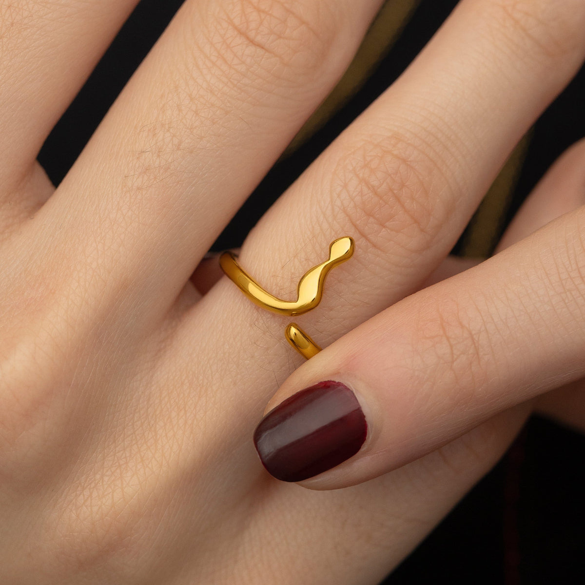 Model adjusting the gold ring they are wearing.