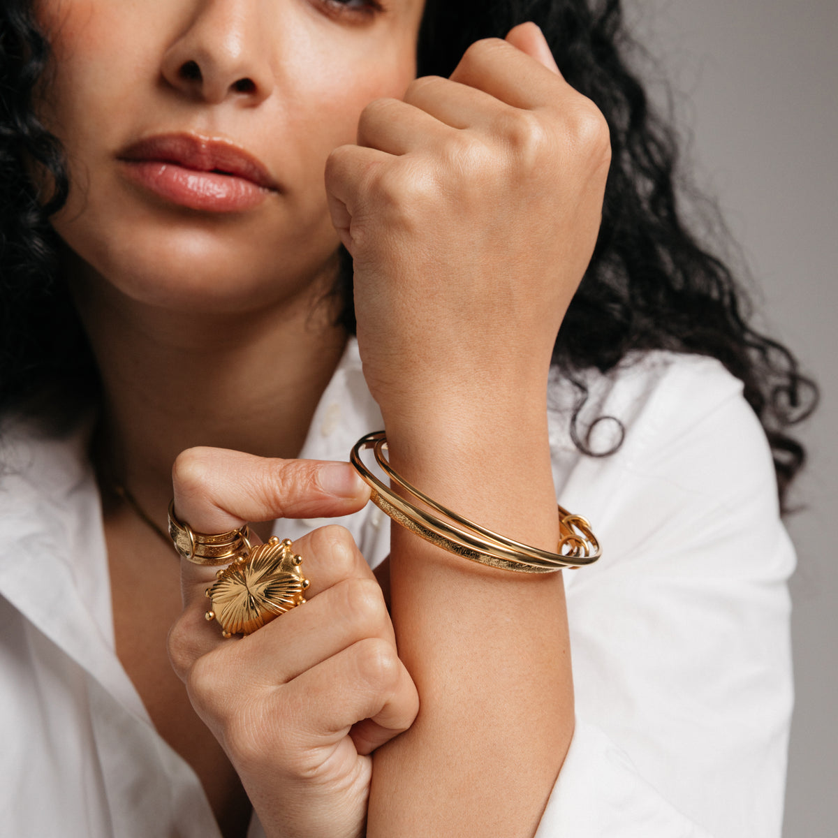 Model styled in 18k gold-plated Nominal jewelry featuring the Ayatul Kursi Bangle Stack paired with the Ayatul Kursi Ring Stack and Dome Statement Ring.