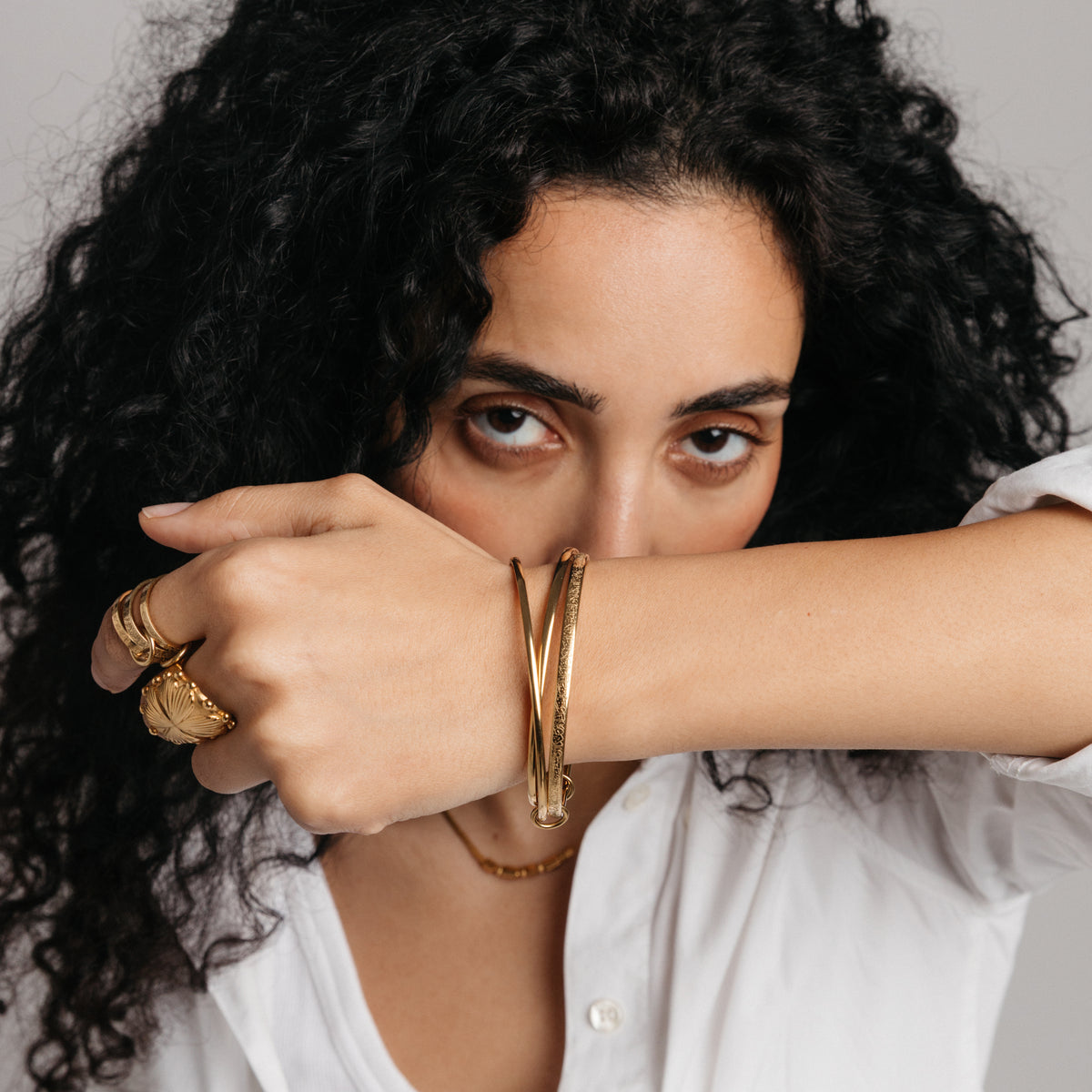 Model styled in 18k gold-plated Nominal jewelry featuring the Ayatul Kursi Bangle Stack paired with the Ayatul Kursi Ring Stack and Dome Statement Ring.