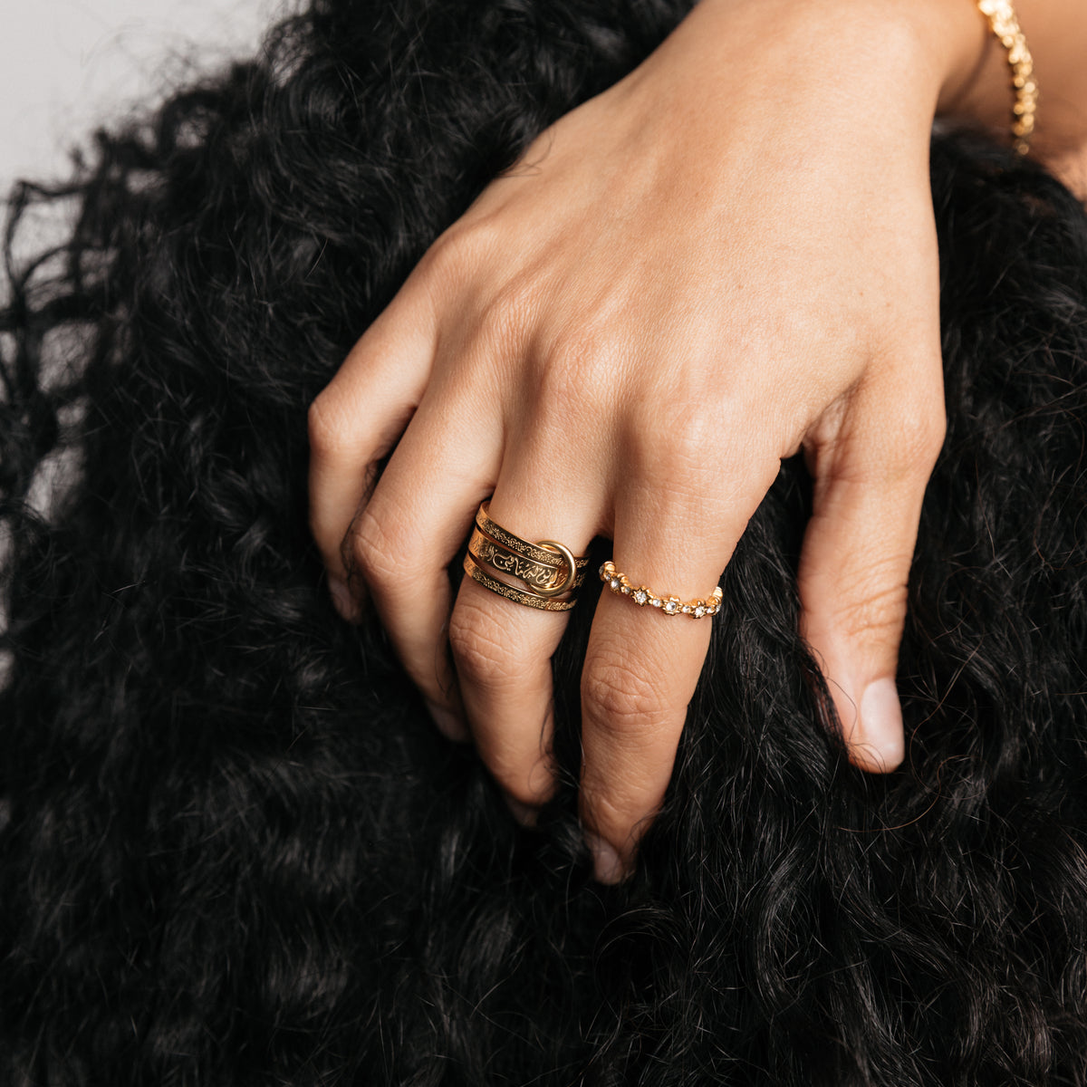 Model styled in 18k gold-plated Nominal jewelry featuring the Ayatul Kursi Ring Stack paired with the Bezel Garden Ring.