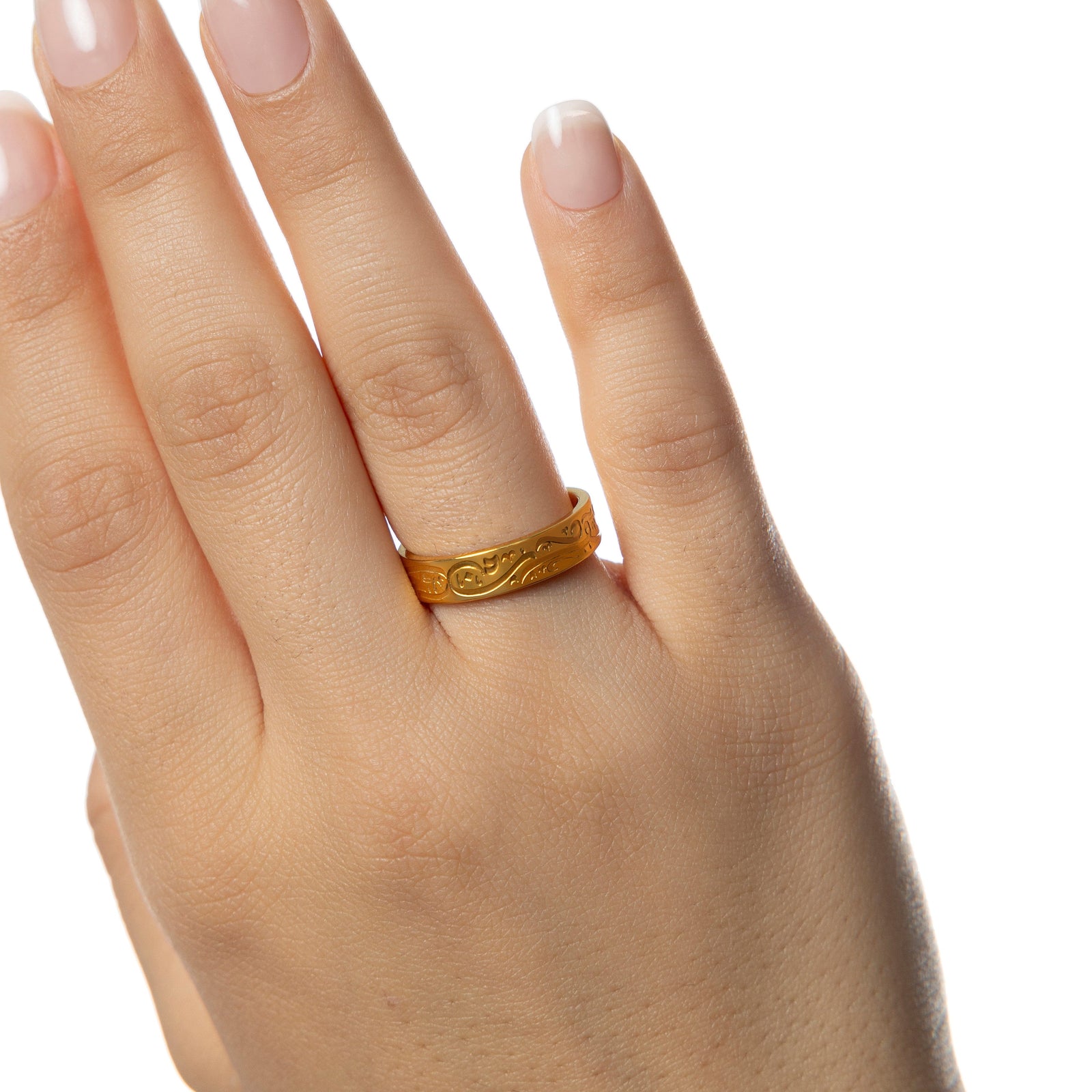 Model's hand with the gold calligraphy ring on the ring finger.