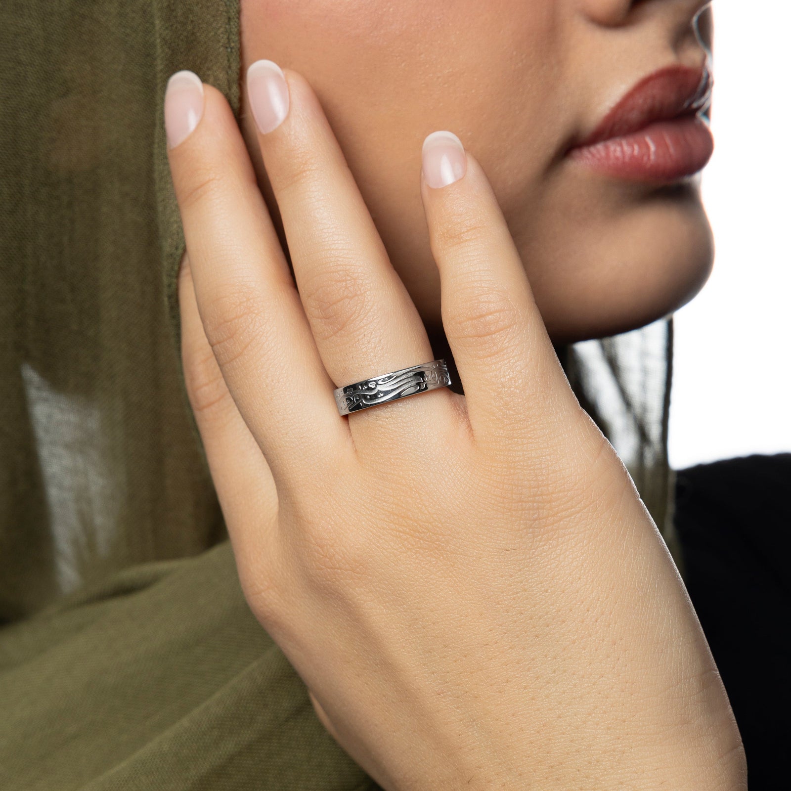 Model wearing the silver “Be, and it is” ring with Arabic engraving.