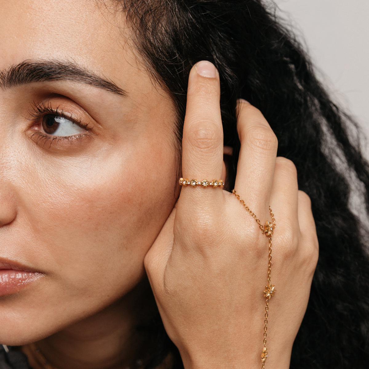 Model styled in 18k gold-plated Nominal jewelry featuring the Bezel Garden Ring paired with the Bezel Bloom Hand Chain