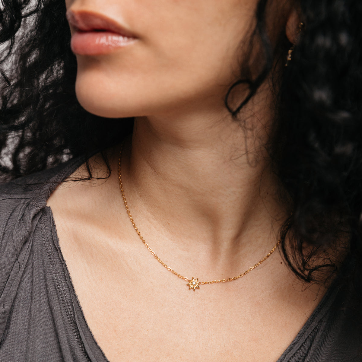Model styled in 18k gold-plated Nominal jewelry featuring the Bezel Bloom Necklace centered with a crystal floral pendant.