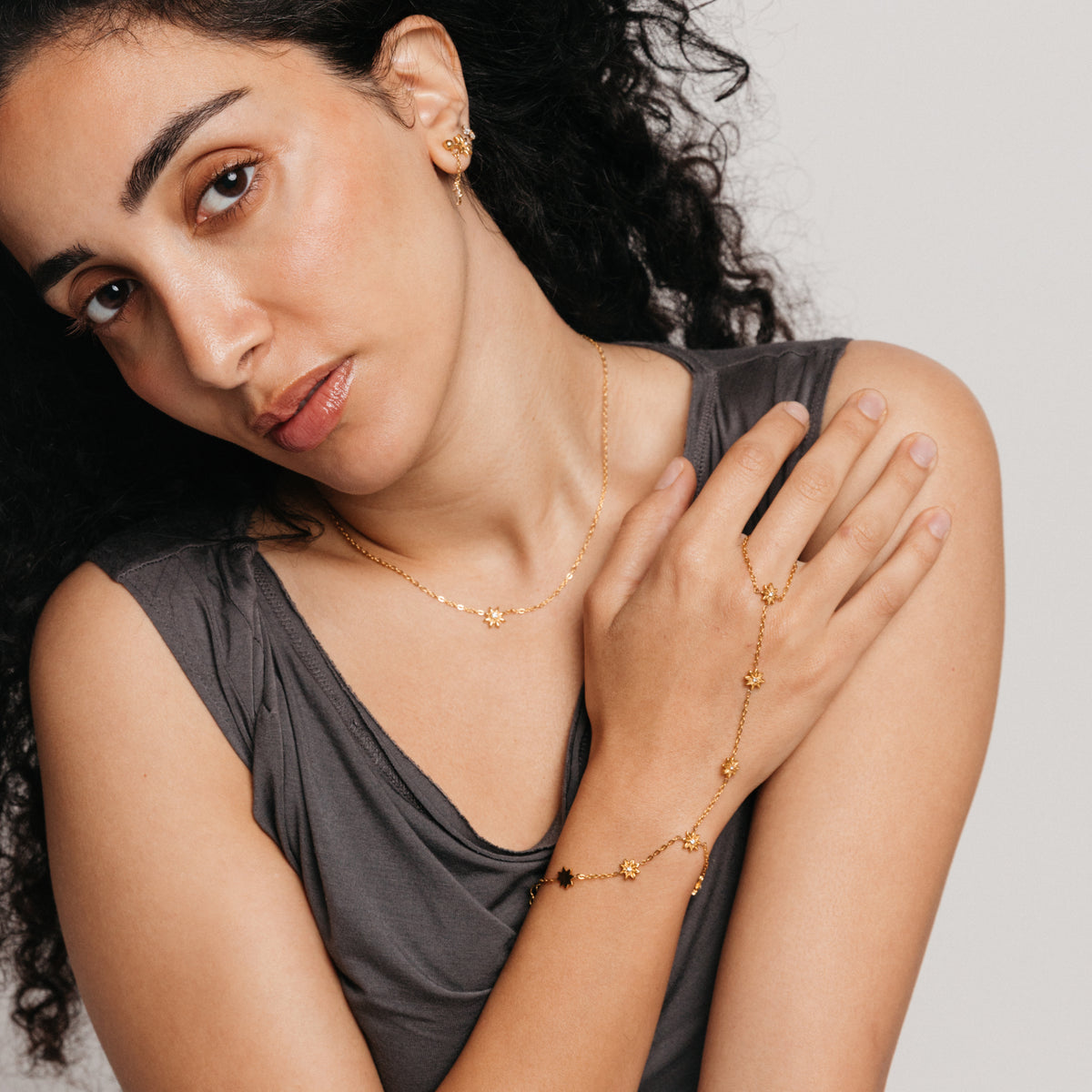 Model styled in 18k gold-plated Nominal jewelry featuring the Bezel Bloom Necklace paired with the Bezel Bloom Hand Chain.