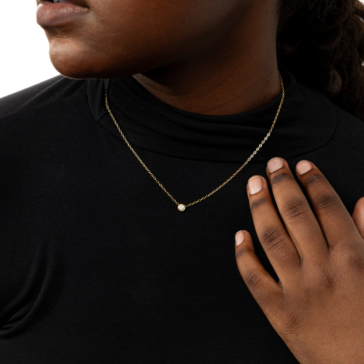 The gold Bezel Necklace as worn by the model.