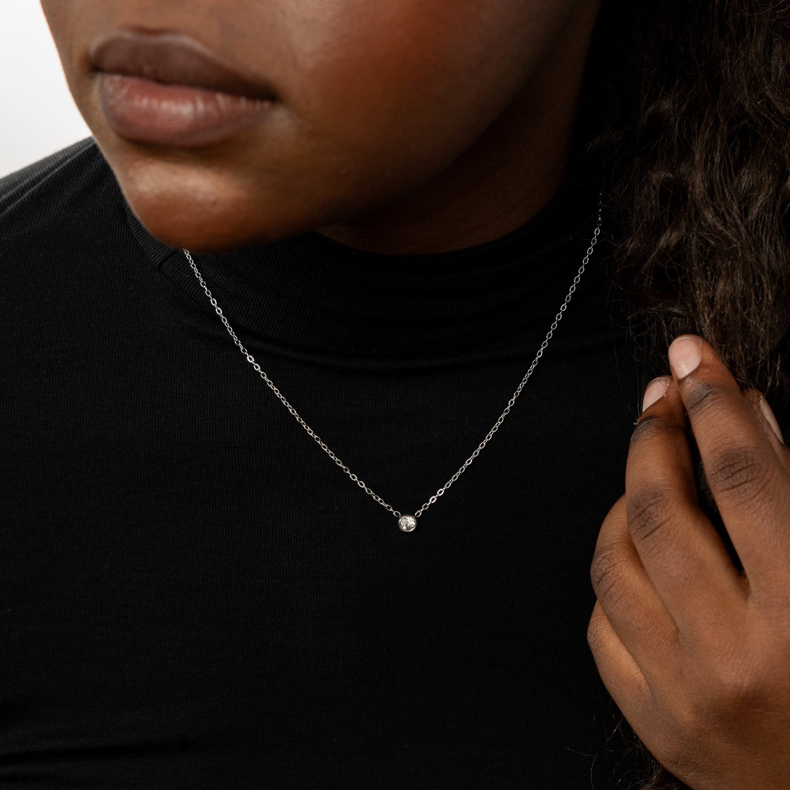 Close up of the silver Bezel Necklace as worn by the model.