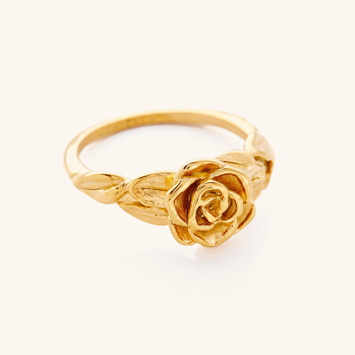 Gold ring featuring a detailed rose design with textured petals and leaves along the band.