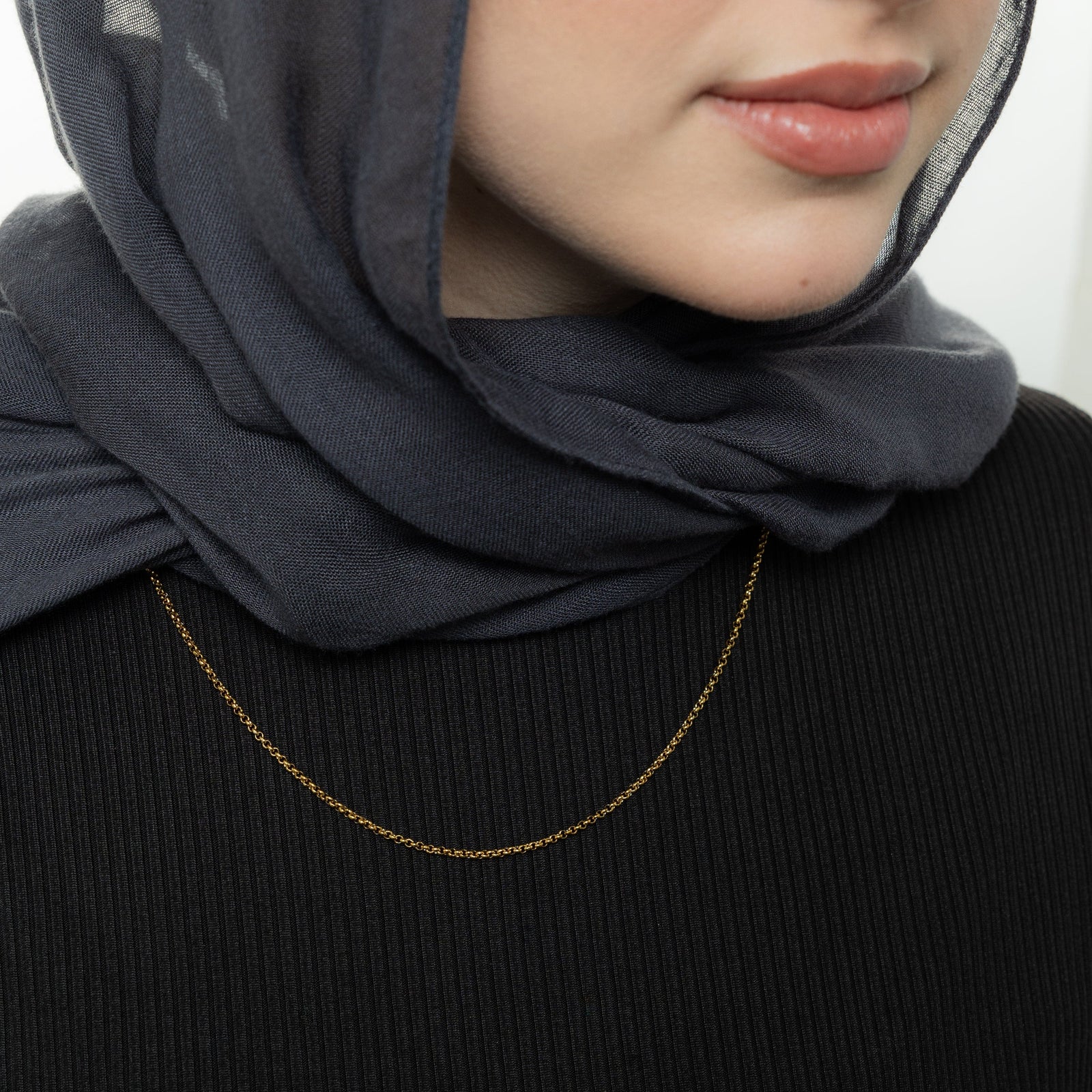 Close up of the gold Micro Box Chain as worn by the model.