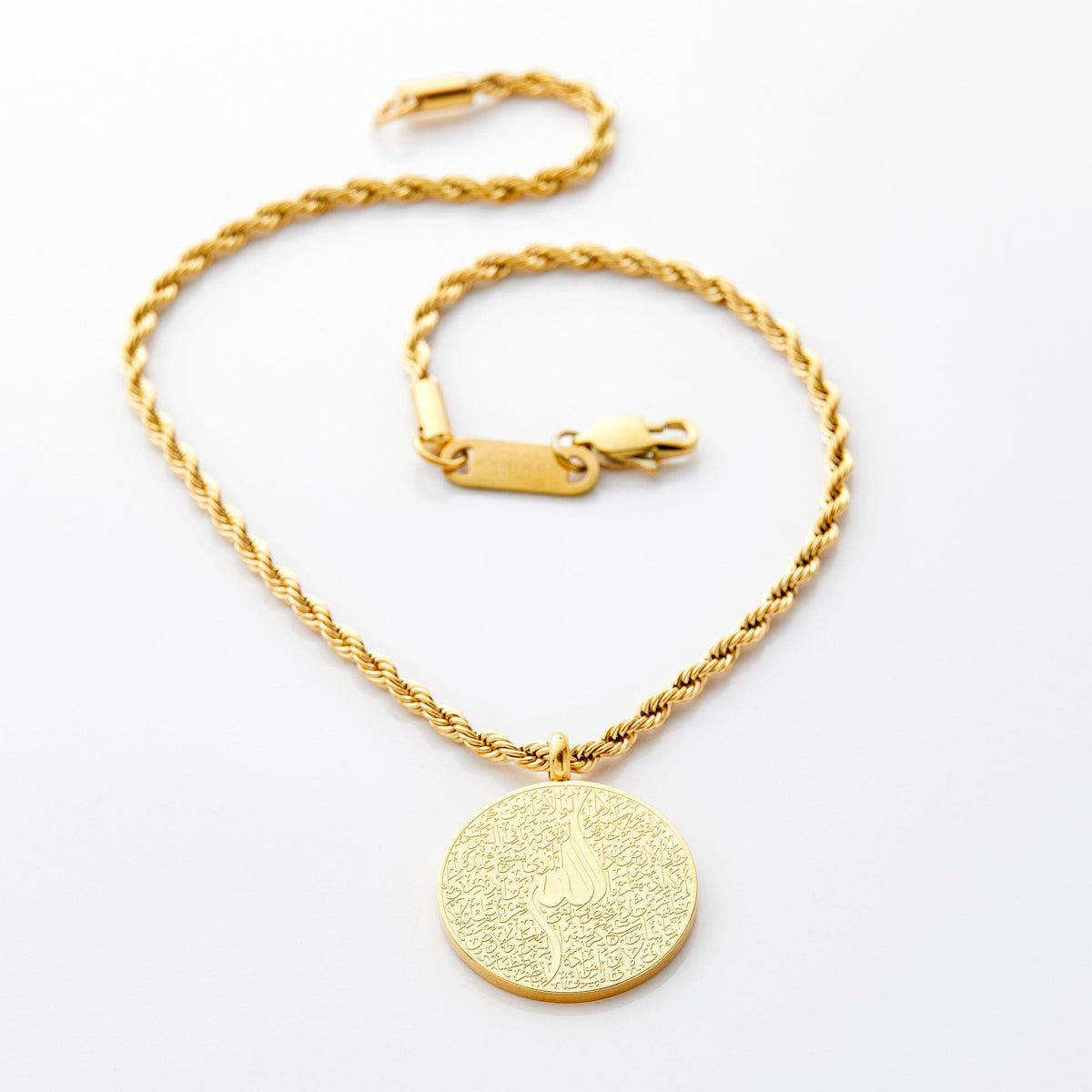 Gold car hanger with a circular pendant engraved in Arabic calligraphy of Ayatul Kursi, styled flat against a white background.