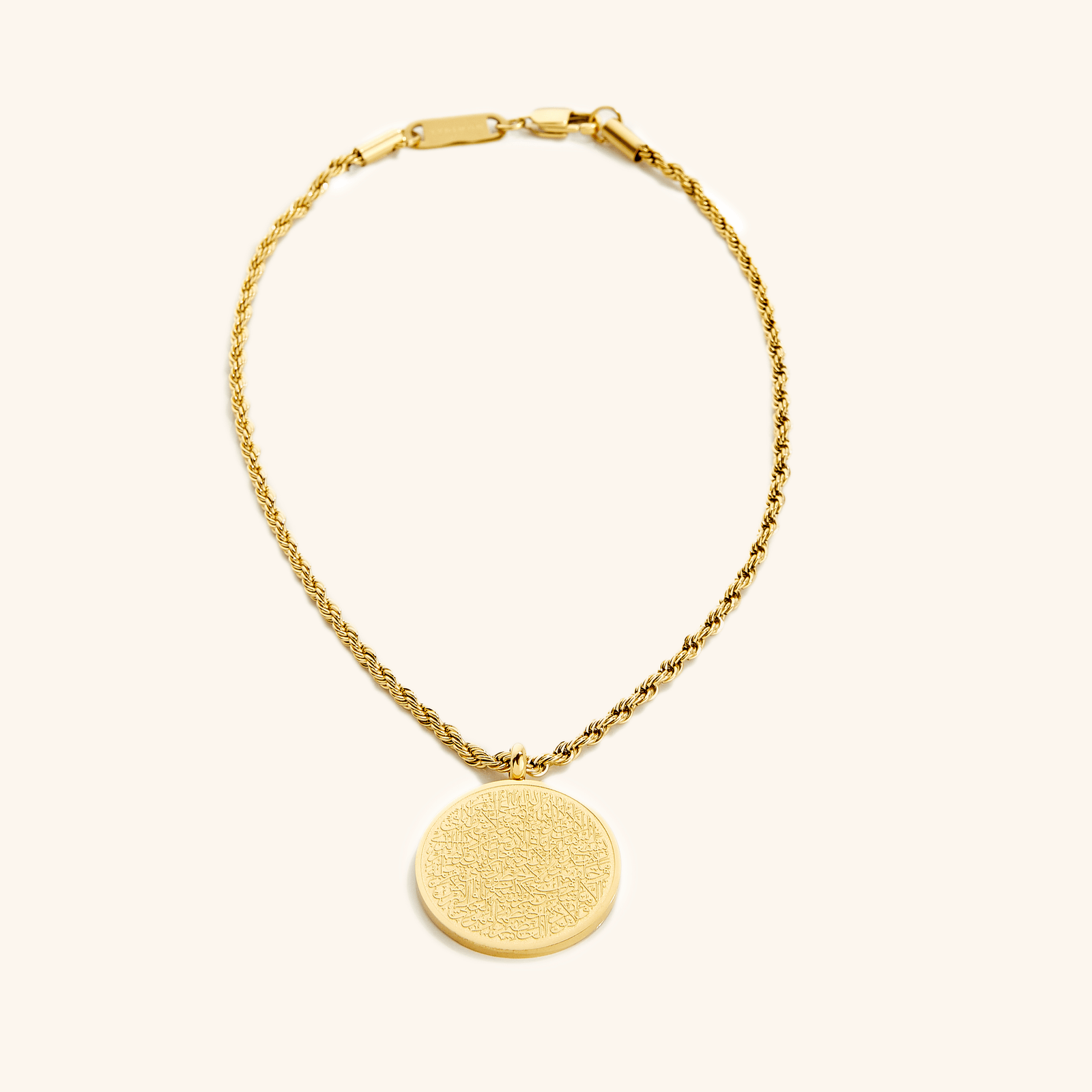 Photo of an 18k gold plated Car Hanger.  A timeless pendant on a classic rope chain, the new Ayatul Kursi Car Hanger uses our classic calligraphy design of the most powerful verse in the Qur'an, now meant to take with you, everywhere you go.