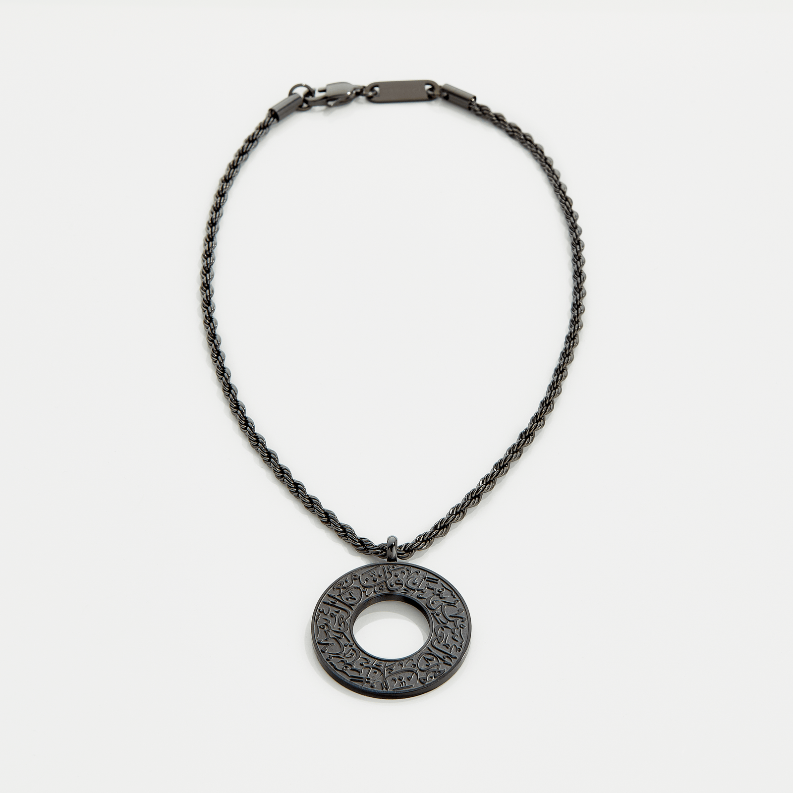 Black car hanger with a circular pendant engraved in Arabic calligraphy reading “With Hardship Comes Ease,” displayed against a neutral background.
