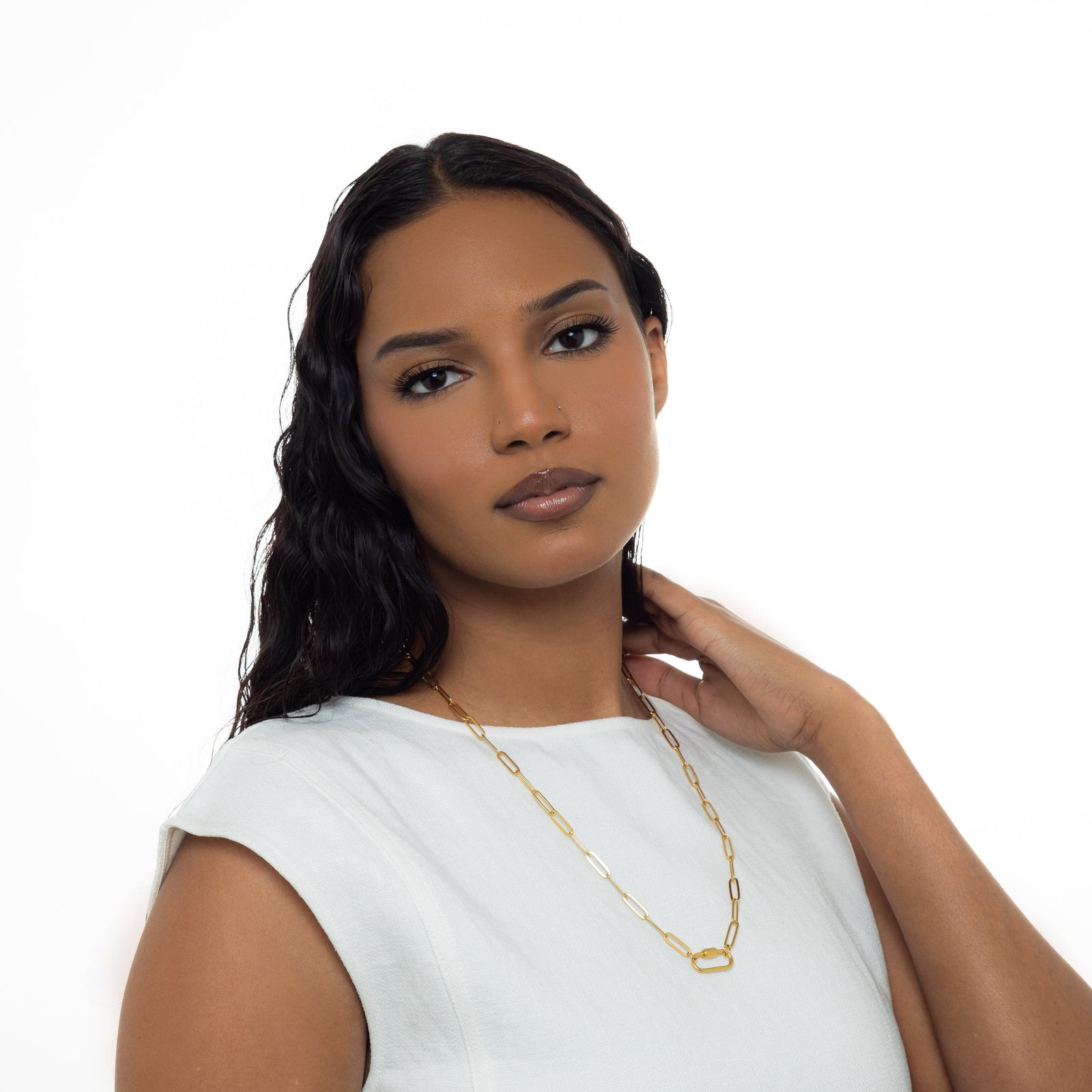 A model wearing the gold-plated Charm Keeper Necklace with a carabiner clasp, showcasing the necklace's design and fit.