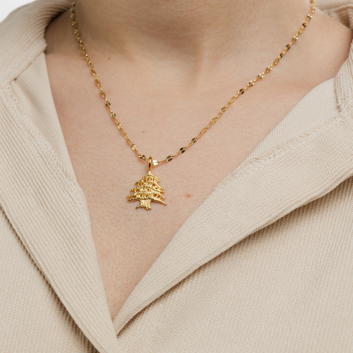 Close up of the gold Cedar of Lebanon Necklace as worn by the model.