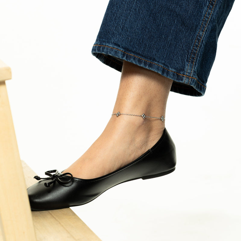 Full view of the silver Dotted Henna Anklet styled on ankle pimage_ paired with cropped denim and black ballet flats pimage_ anklet resting above the shoe line.