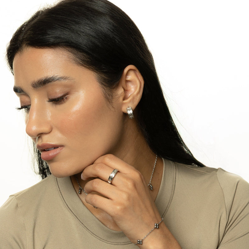 Woman wearing silver Henna Hoops styled with Henna Choker and matching Ring pimage_ paired with beige top and sleek hair.