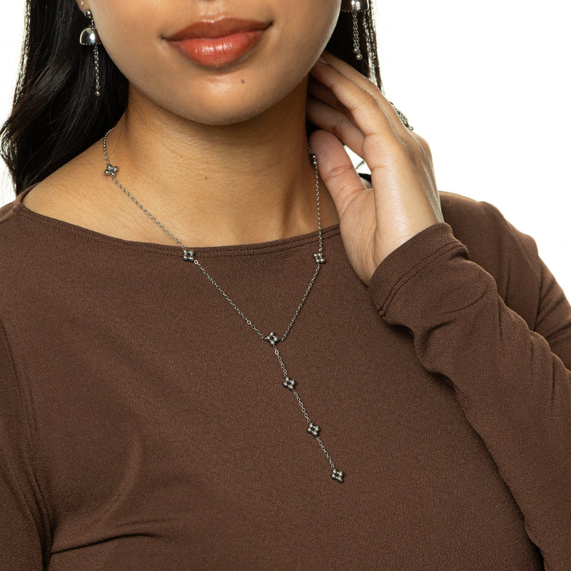 Woman wearing the silver Henna Lariat Necklace with hand resting near neckline.