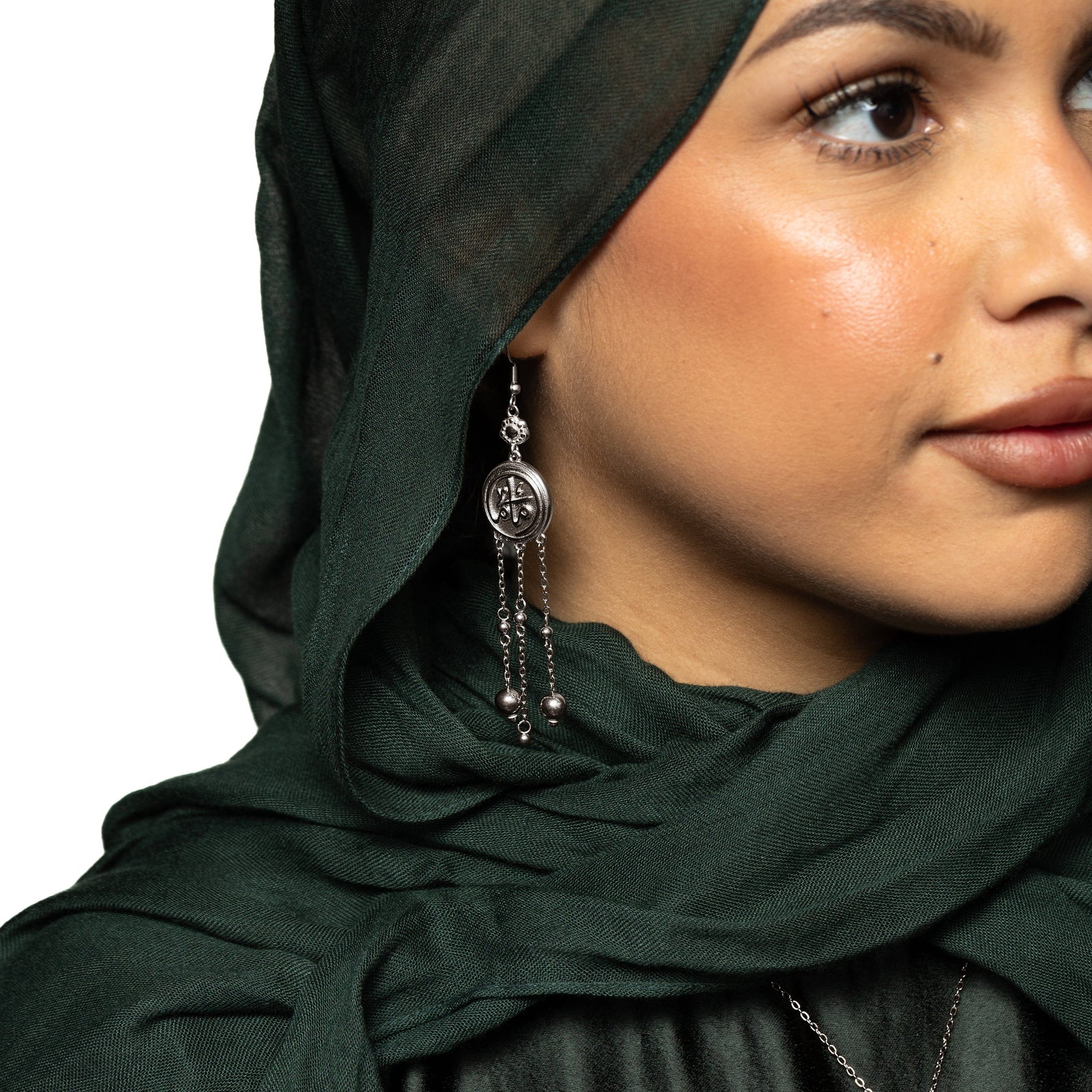Photo of the model wearing the silver Coin Mama Earrings on their right ear.