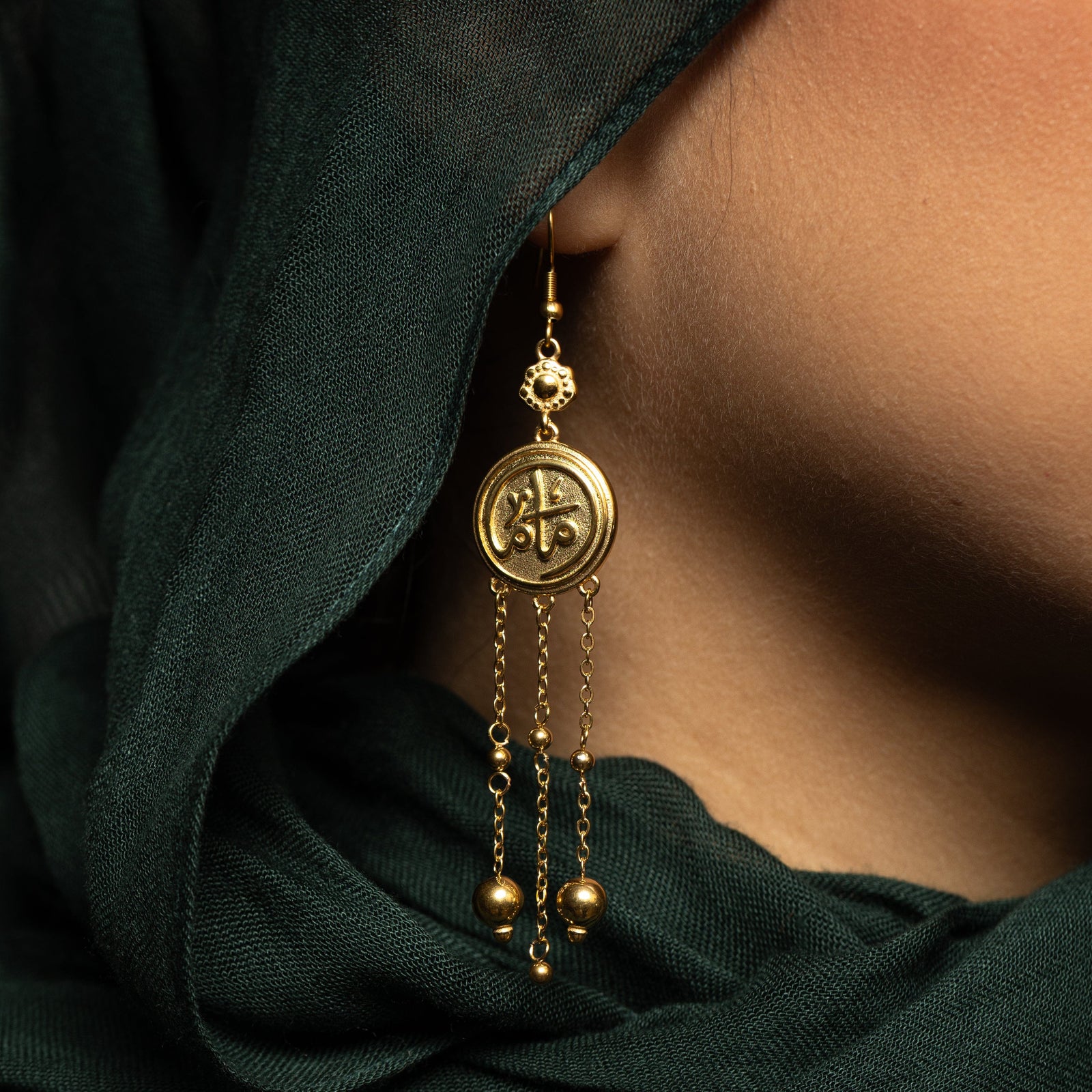 Close up of the gold coin Mama Earrings worn by a model.