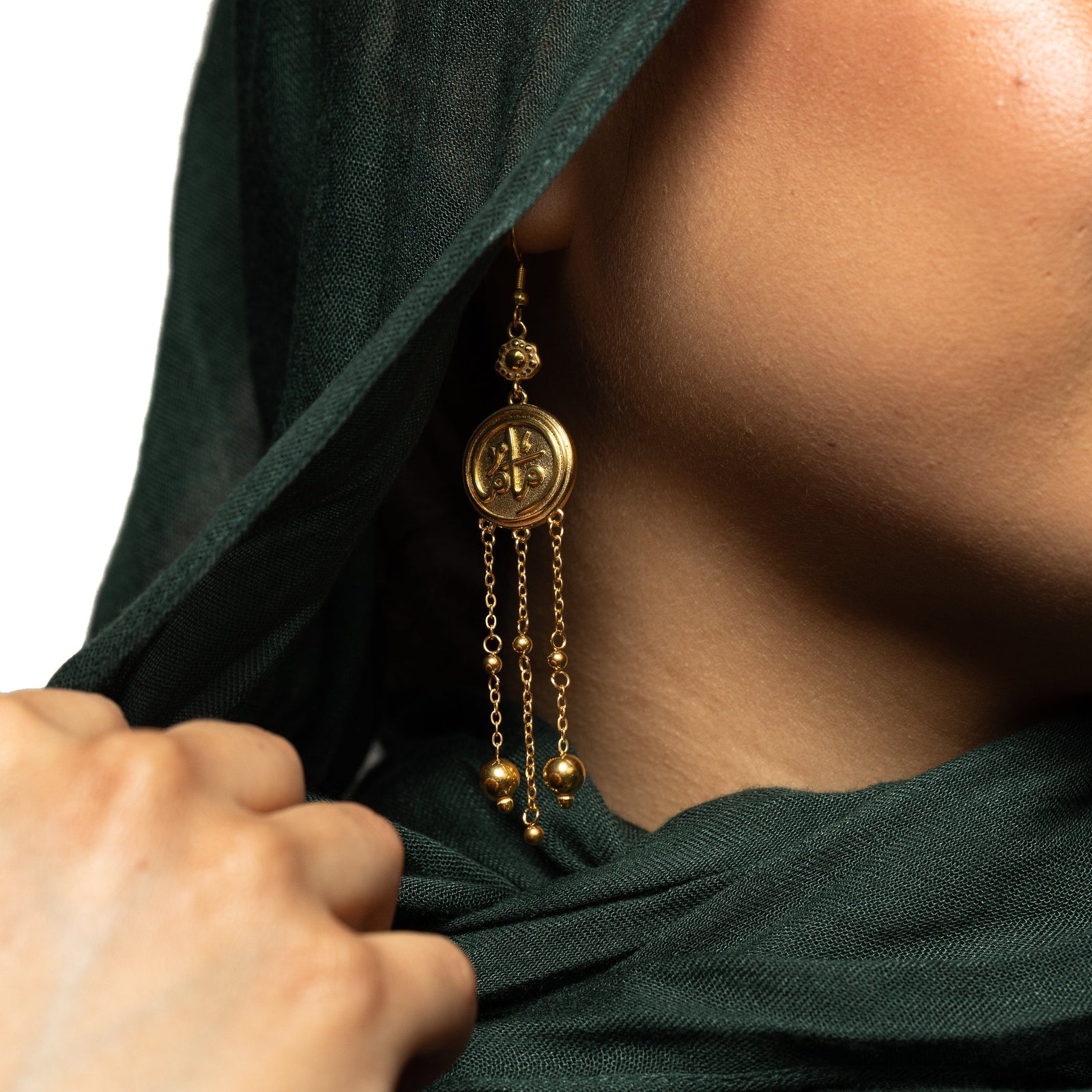 Close up of the gold coin Mama Earrings worn by a model.