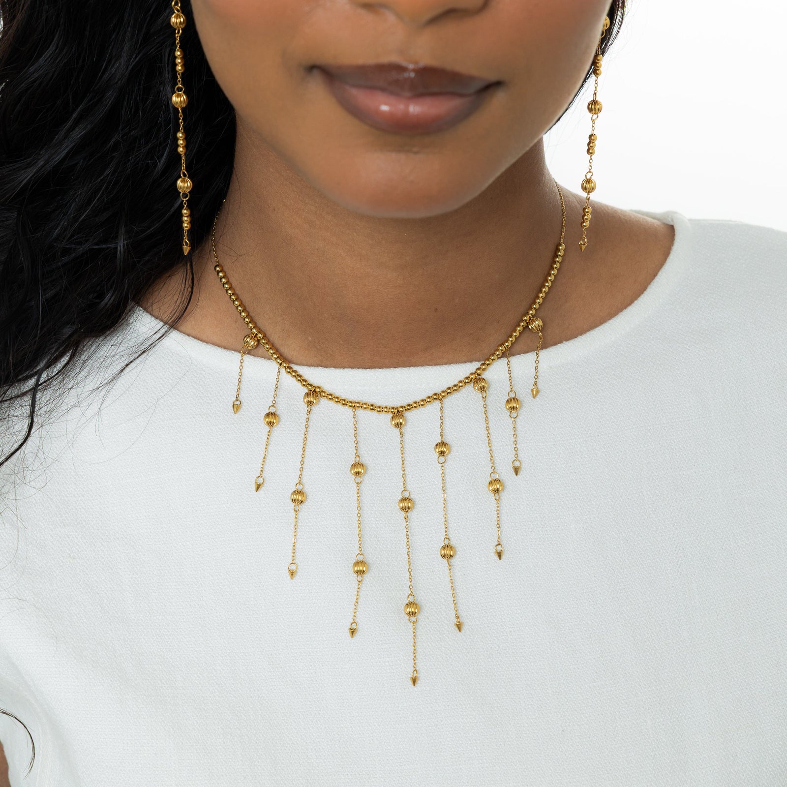 Close up of the gold Comet Choker against the white fabric of the model's shirt.