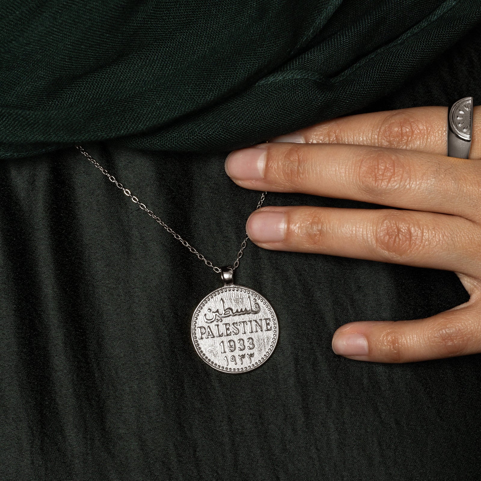 Close up of the silver Country Coin Necklace - Palestine as worn by the model.