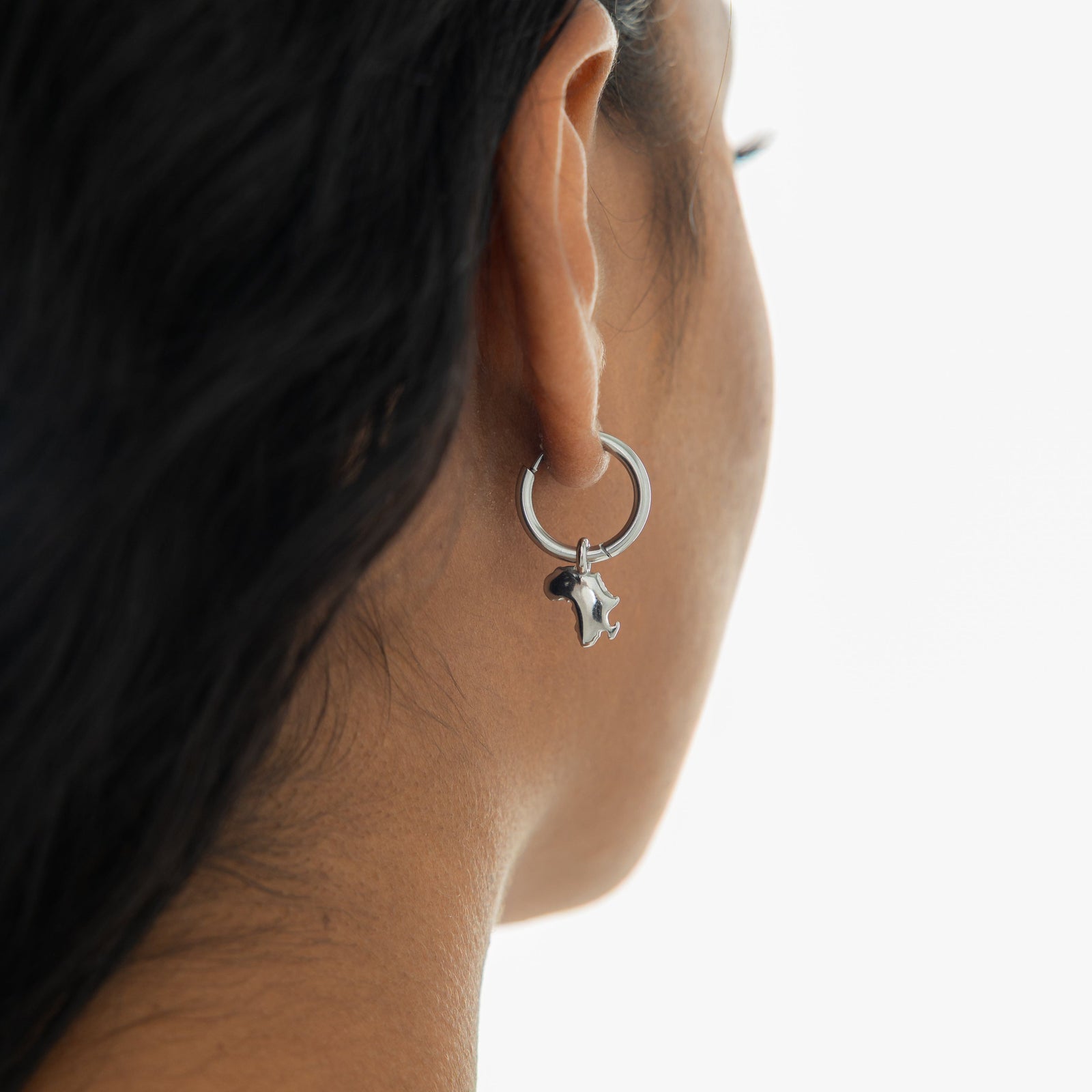 Close up of the silver Country Map Hoops as worn by the model on their right ear.
