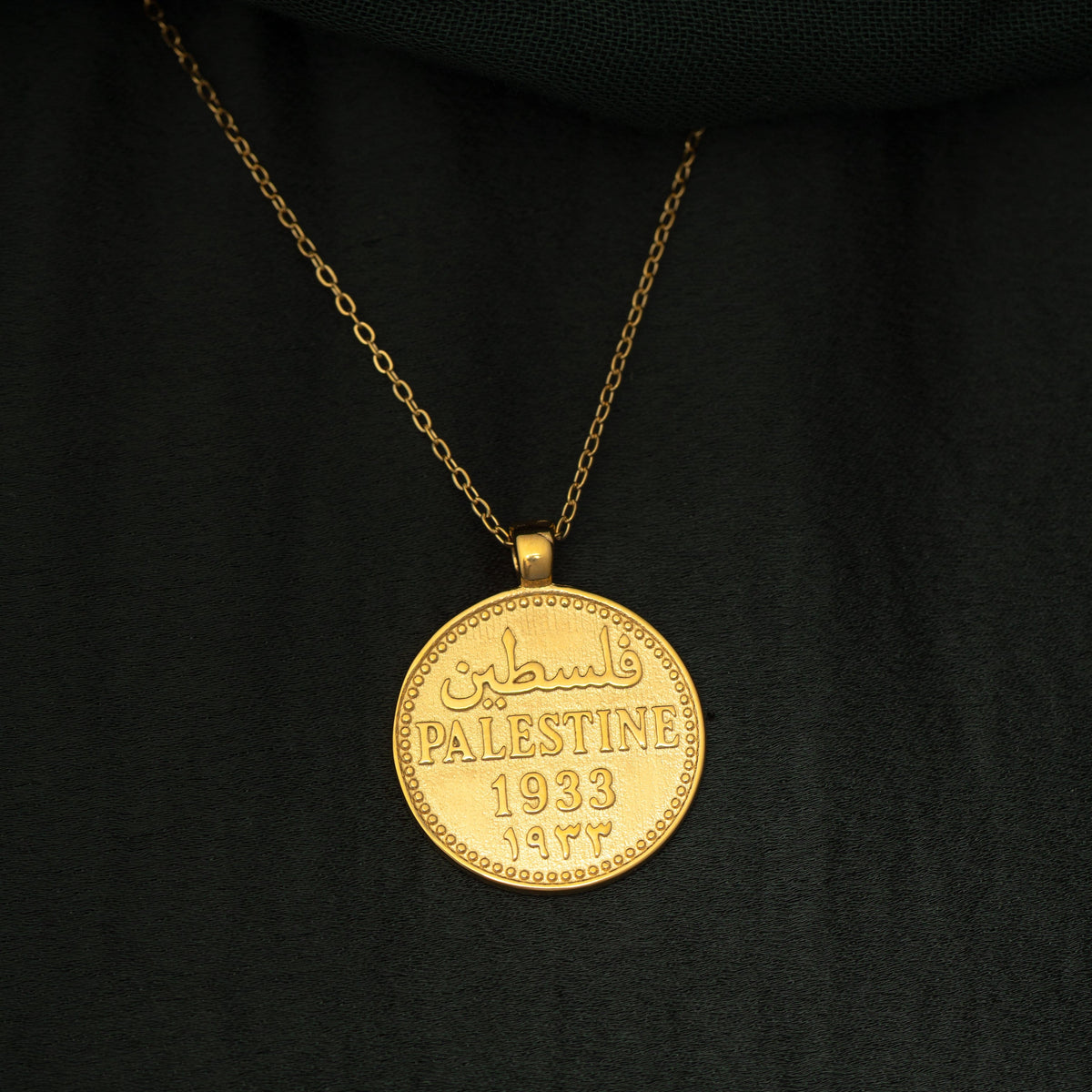 Close up of the Country Coin Necklace - Palestine against a black background.