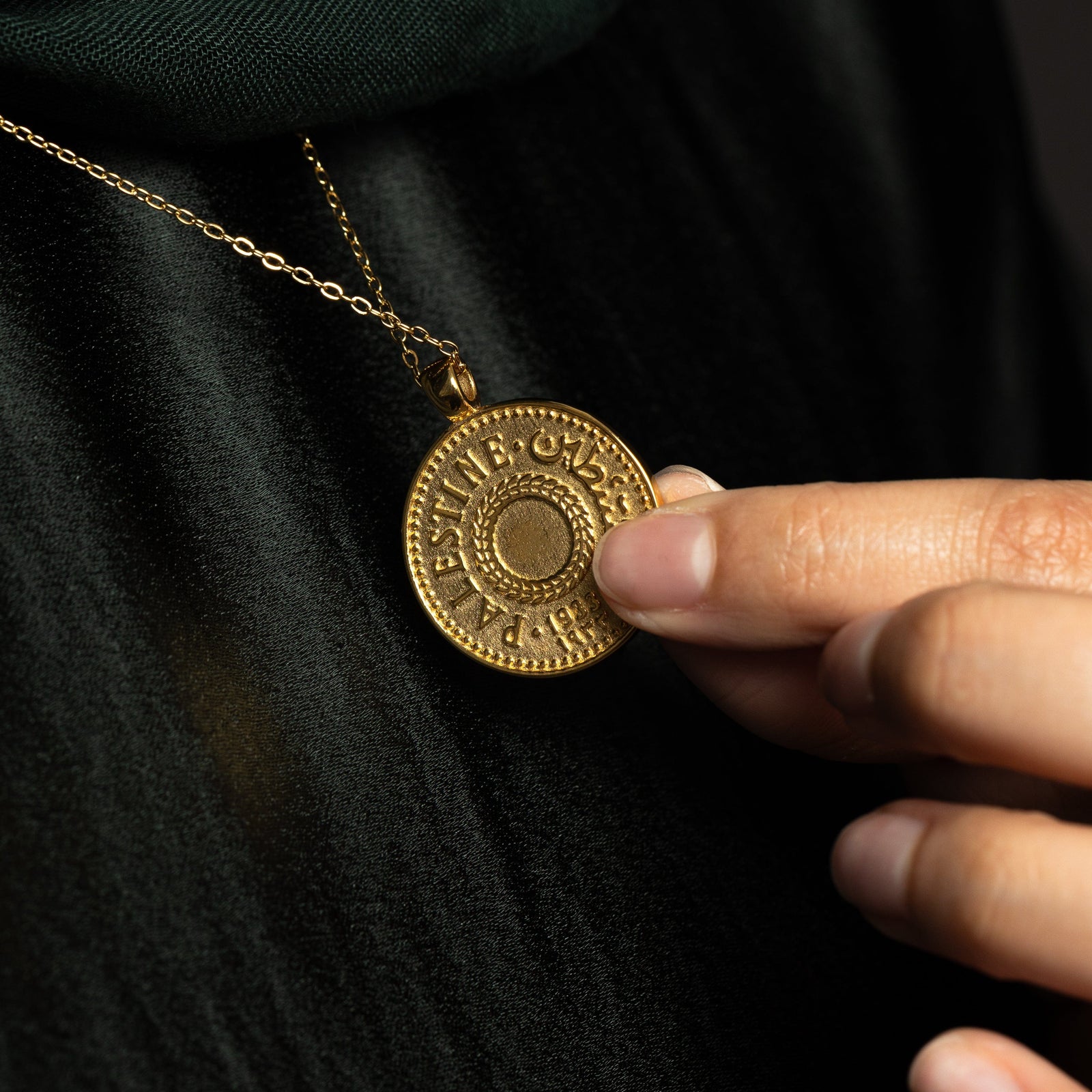 Close up of the back design of the Gold Palestine coin pendant.