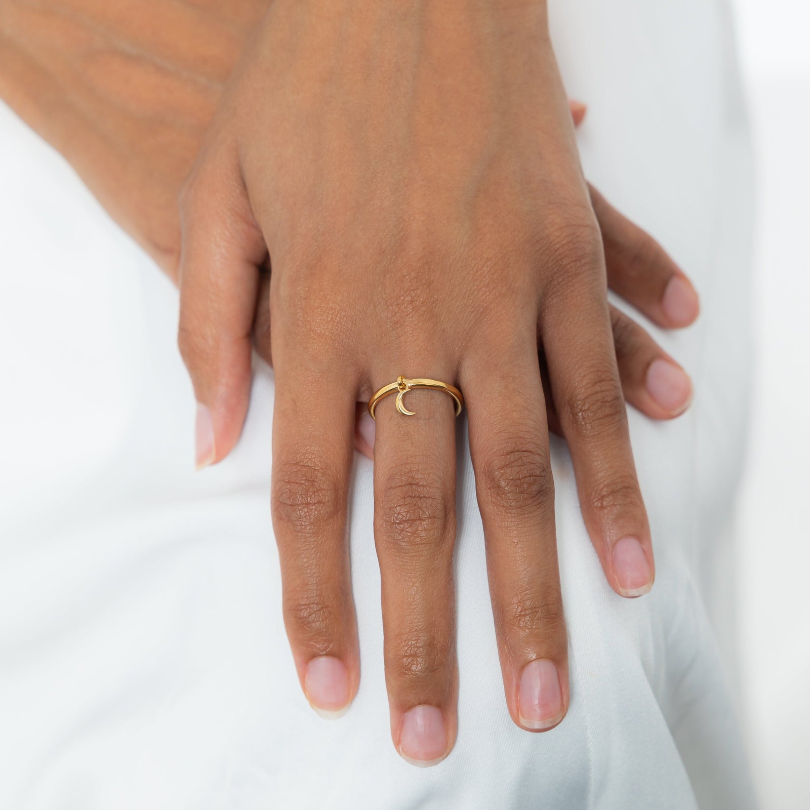 Hand shot with the gold crescent ring worn on the middle finger