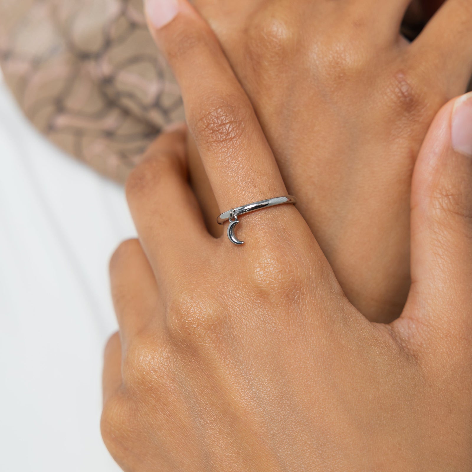 Hand shot with the silver crescent ring worn on the index finger
