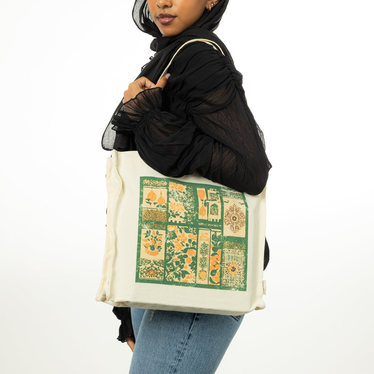 Photo of the model wearing the Culture Collage Tote on their left shoulder.