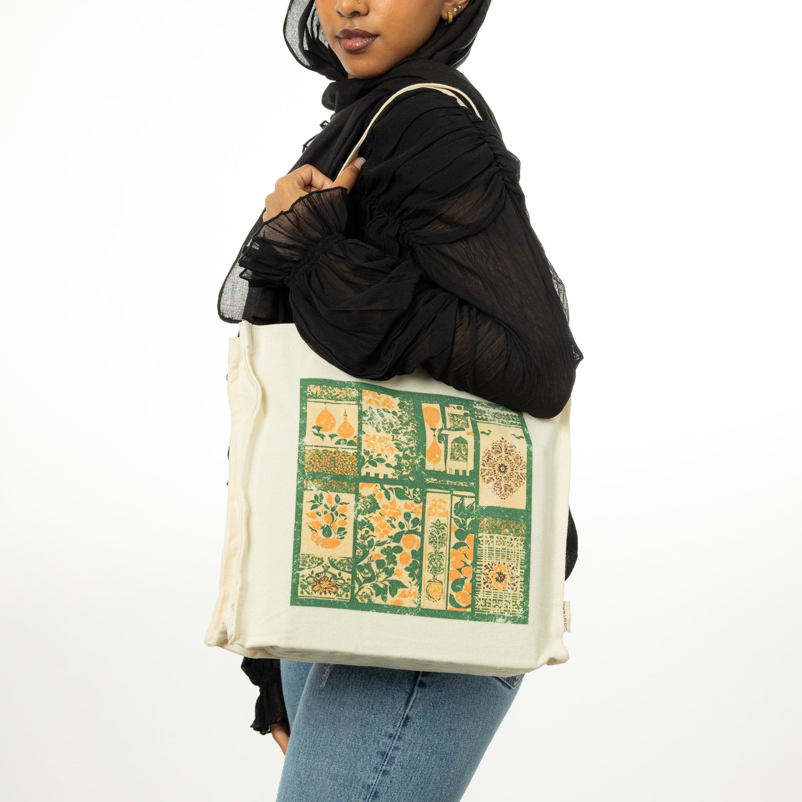 Photo of the model wearing the Culture Collage Tote on their left shoulder.