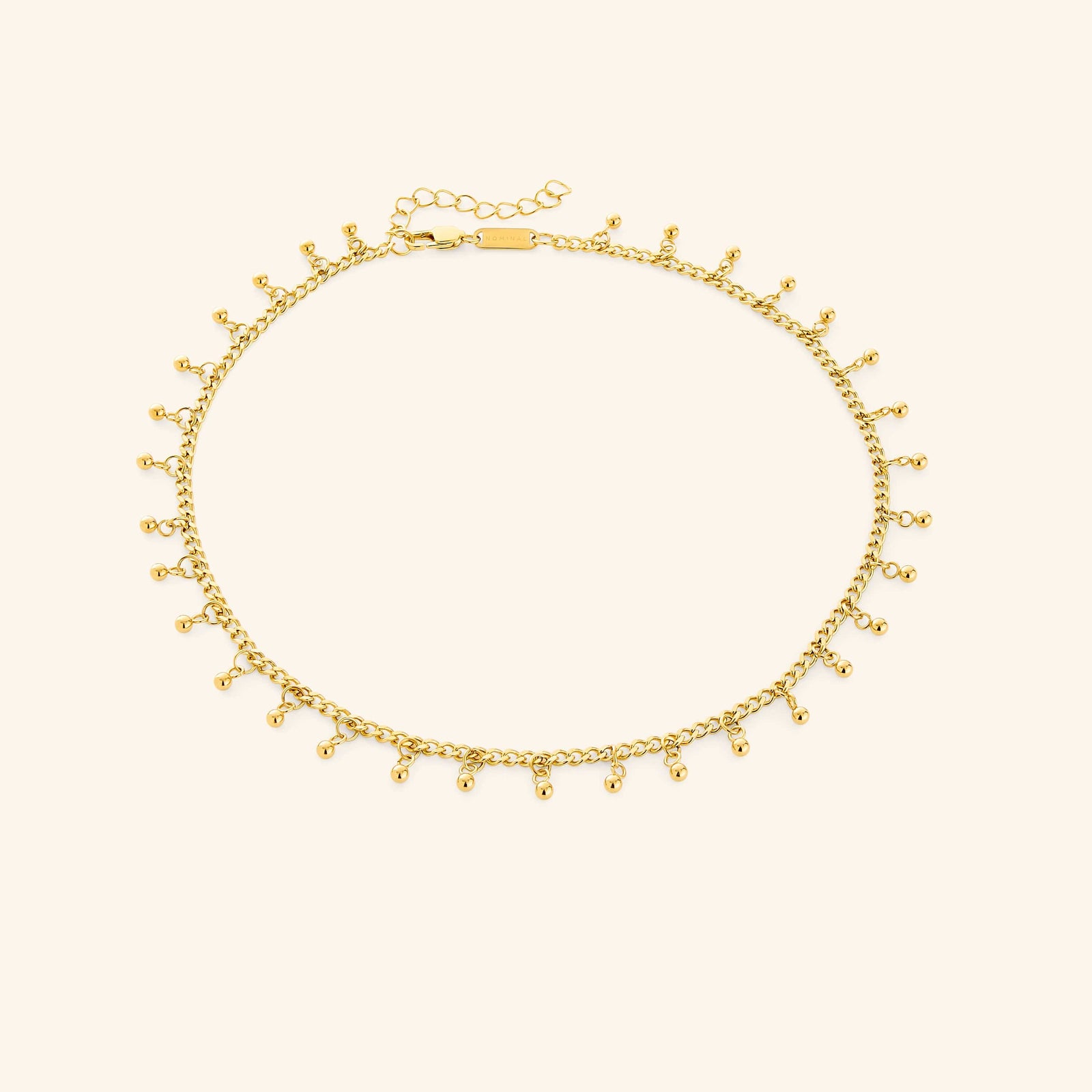 A close-up of the Dangling Dotted Choker in 18K gold plating. The choker features a delicate chain with evenly spaced 3mm spherical bead accents that dangle, creating a subtle and elegant design.