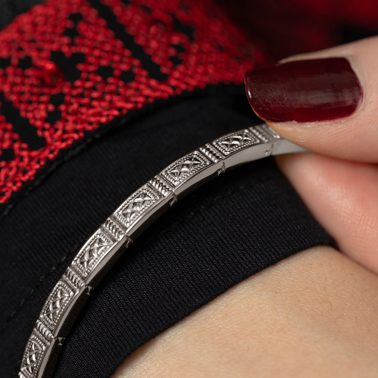 Close up photo of the silver Damascus Tile Bangle as worn by the model.