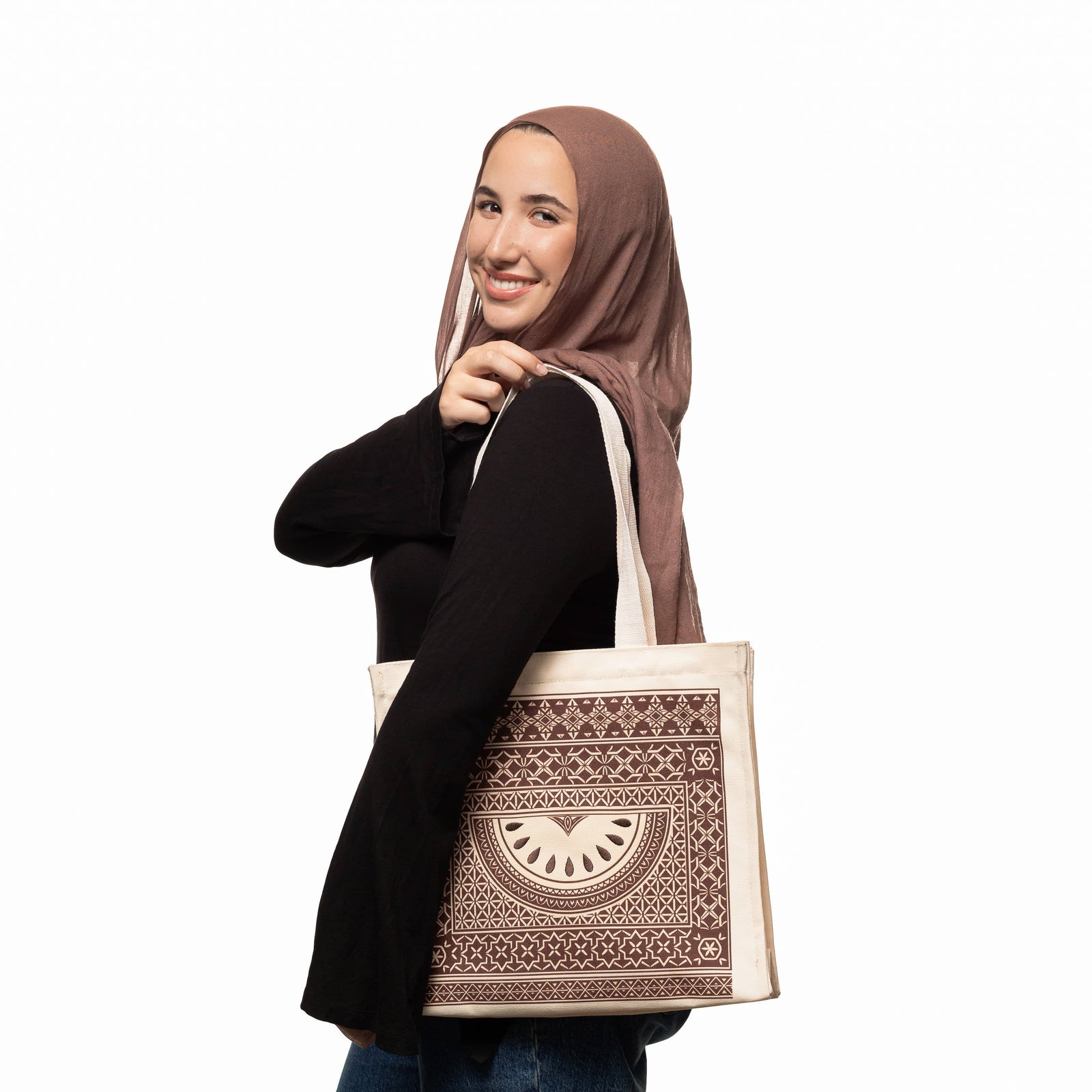 Photo of the model smiling while carrying the Damascus Mosaic Watermelon Tote on their shoulder.
