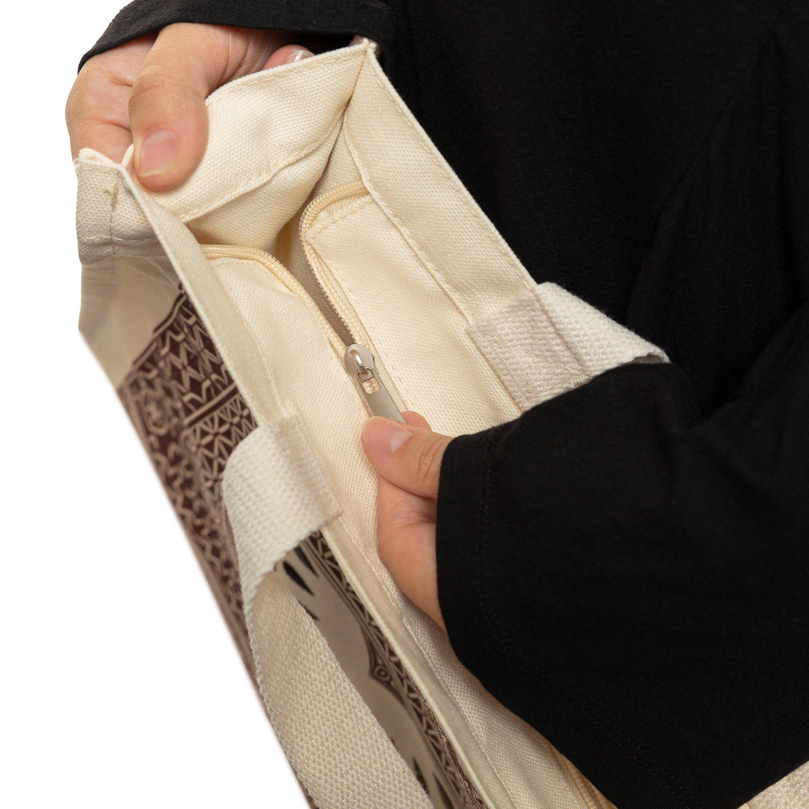 Close up photo of the model closing the zipper of the bag.