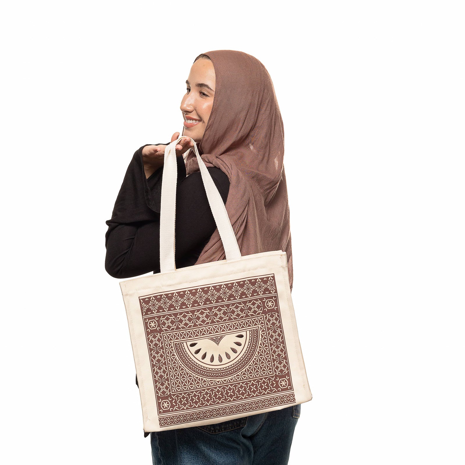 Photo of the model holding the bag by its strap.